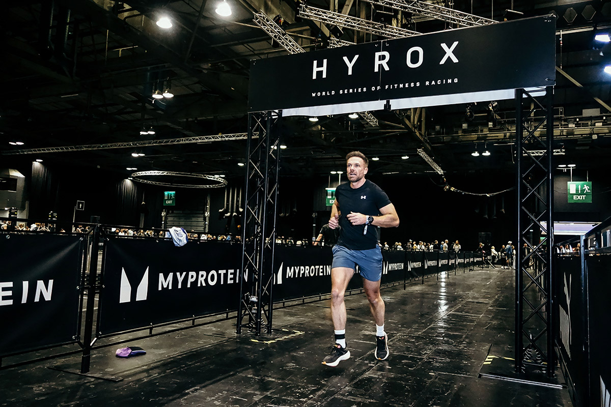 A first-time HYROX competitor crossing the finish line, celebrating after completing his first race.
