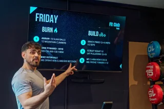 Fit Club York coach explaining a workout session on a screen inside the gym