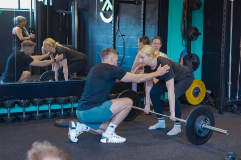 Fit Club York coach helping a member with lifting technique during training