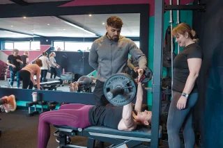 Fit Club York coach supporting members during a strength training workout session